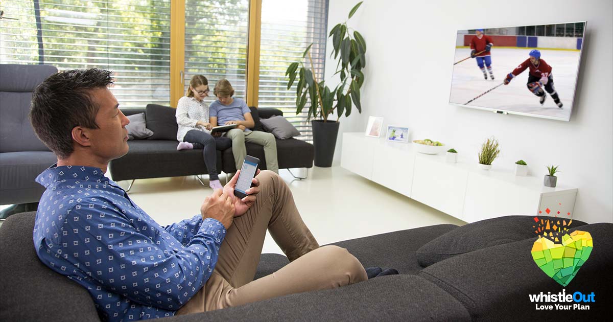 A family watching TV on phone, tablet, and television set